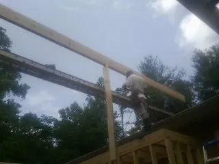 Carpenter setting a ridge beam over a new addition frame — Ice Dam Removal by Roofing Brothers in Delphi Falls