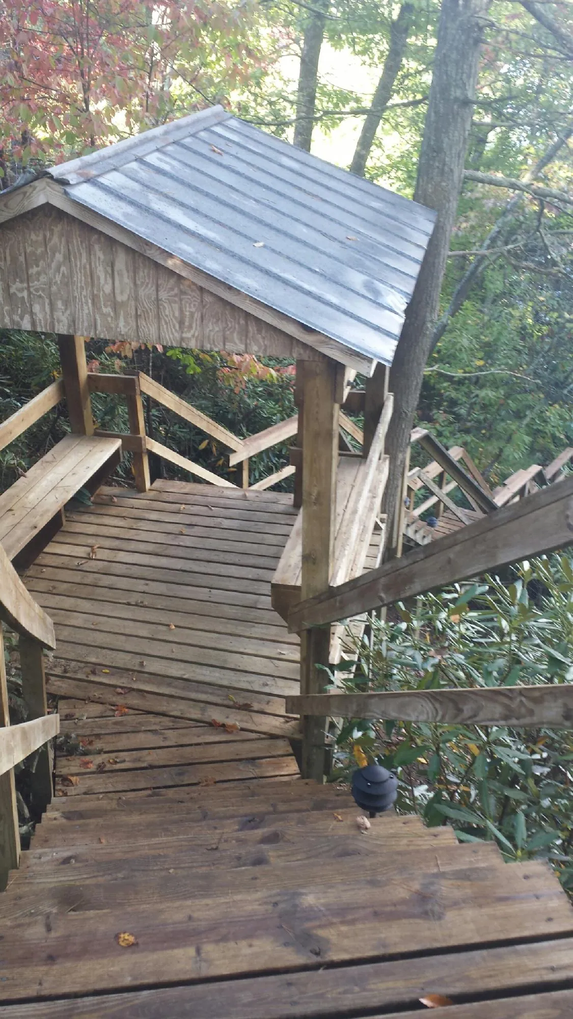 Metal roofed shelter over wooden steps on a wooded walkway — Skylight Repair & Installation work by our crew in Delphi Falls