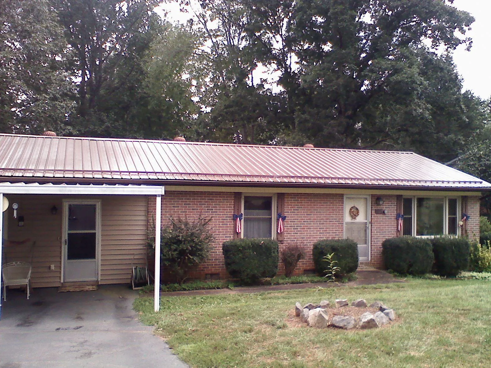 Bronze metal roof and carport on a brick ranch home — Roof Repair work by our crew in Delphi Falls